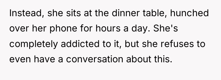 Instead, she sits at the dinner table, hunched over her...
