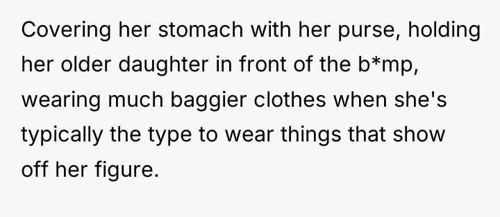 Covering her stomach with her purse, holding her older daughter...