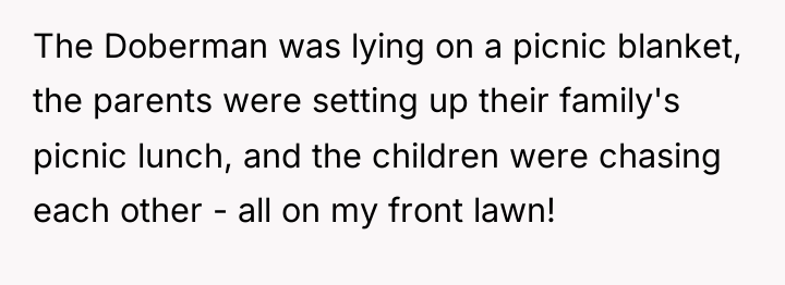 The Doberman was lying on a picnic blanket, the parents...